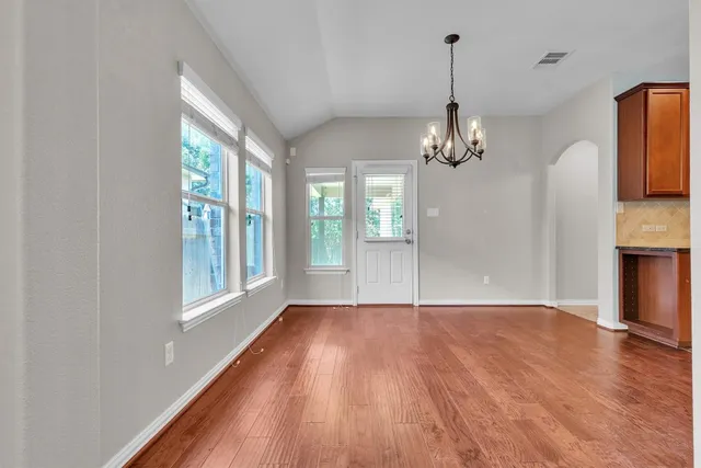 a view of a room with wooden floor fireplace and windows