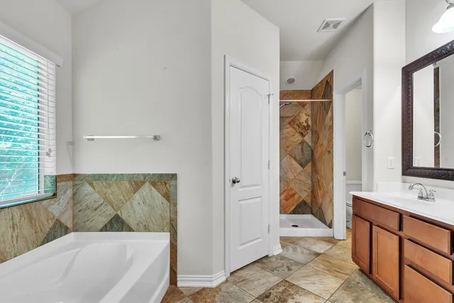 a bathroom with a tub a sink and a shower