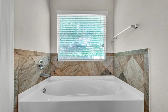 a bathroom with a bathtub and window