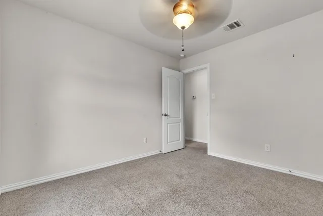 an empty room with a chandelier fan and a chandelier fan