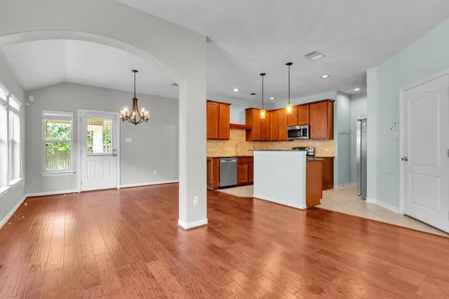 a view of a kitchen with a refrigerator wooden floor and a kitchen