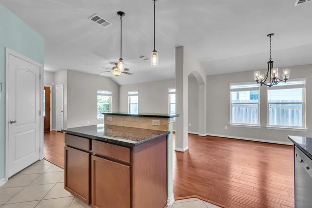 a kitchen with stainless steel appliances granite countertop a sink a counter space and a chandelier