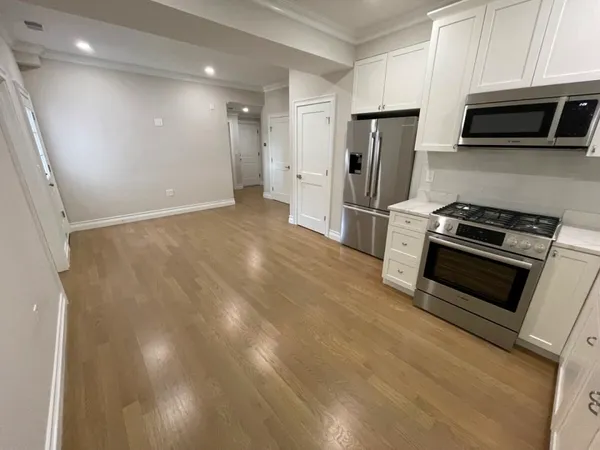 a kitchen with stainless steel appliances a refrigerator a stove top oven a sink and dishwasher