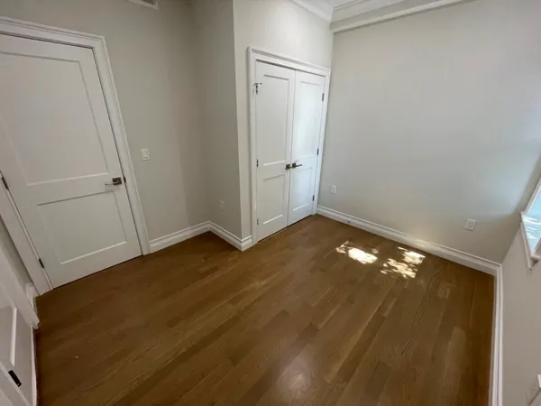 a view of an empty room with wooden floor