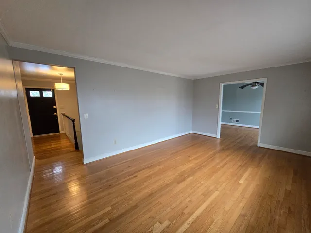 a view of empty room with wooden floor