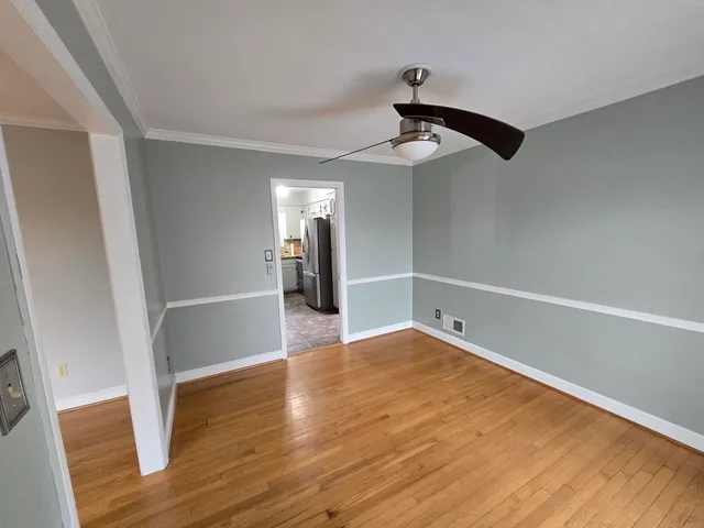 a view of empty room with wooden floor