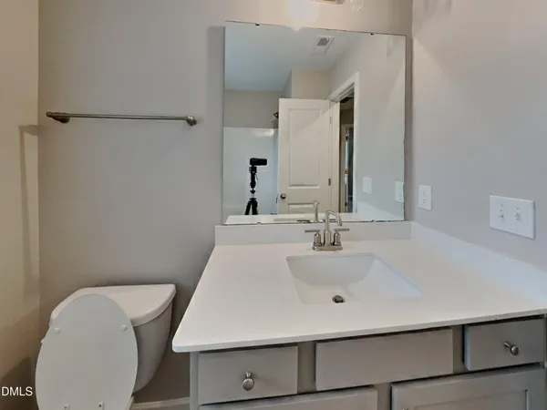 a bathroom with a sink a toilet and mirror