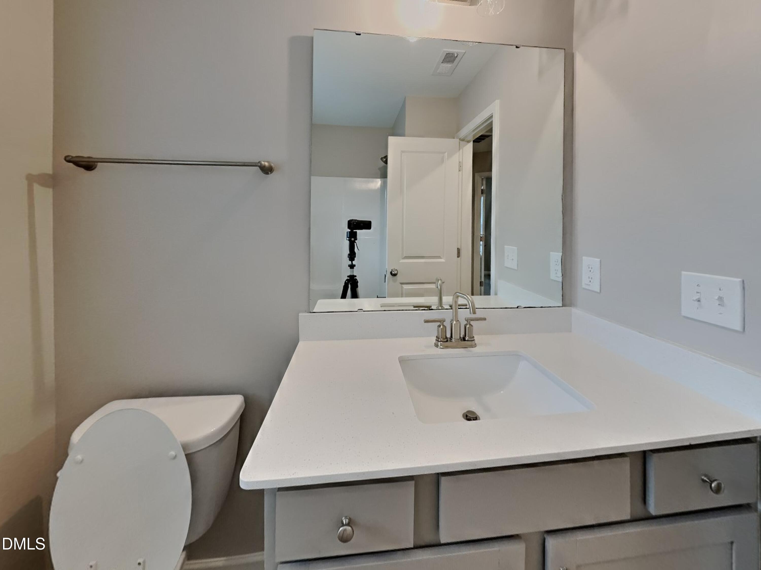 803 Springtooth Drive Zebulon, NC 27597 - Photo 14 of 16 a bathroom with a sink a toilet and mirror