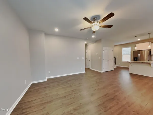 a view of an empty room with a ceiling fan and window