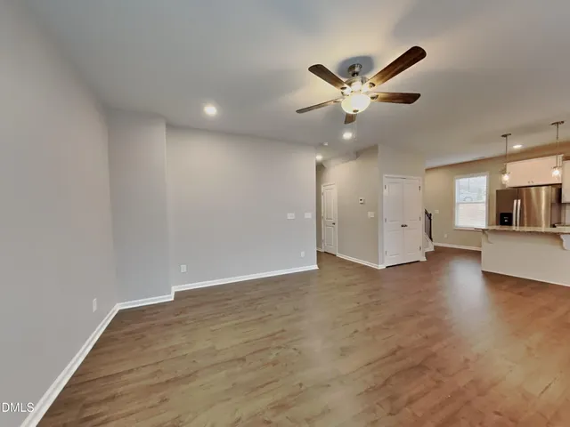 a view of an empty room with a ceiling fan and window