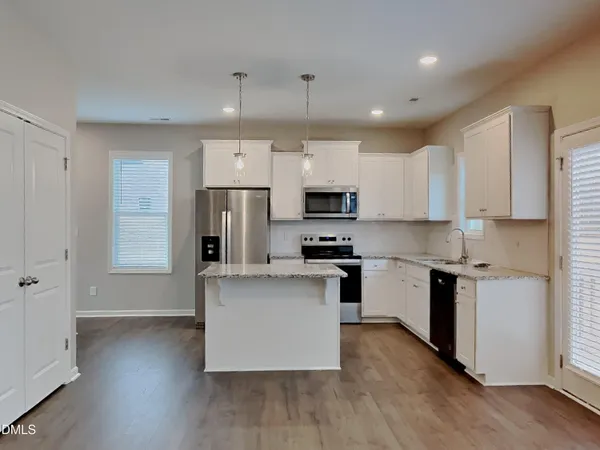 a kitchen with stainless steel appliances a refrigerator sink and microwave