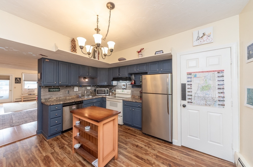 40 Nashua Street, Unit 5 Clinton, MA 01510 - Photo 11 of 33 a kitchen with stainless steel appliances granite countertop a refrigerator a sink dishwasher a stove and white countertops with wooden floor