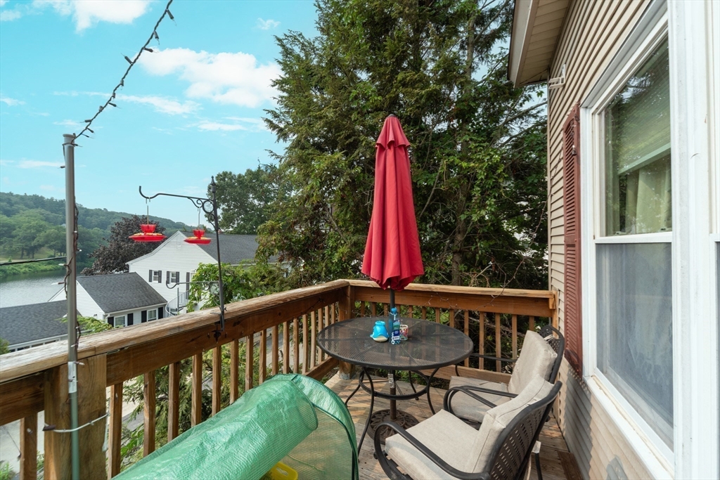 40 Nashua Street, Unit 5 Clinton, MA 01510 - Photo 27 of 33 a view of a balcony with a dining table and chairs with wooden floor and fence