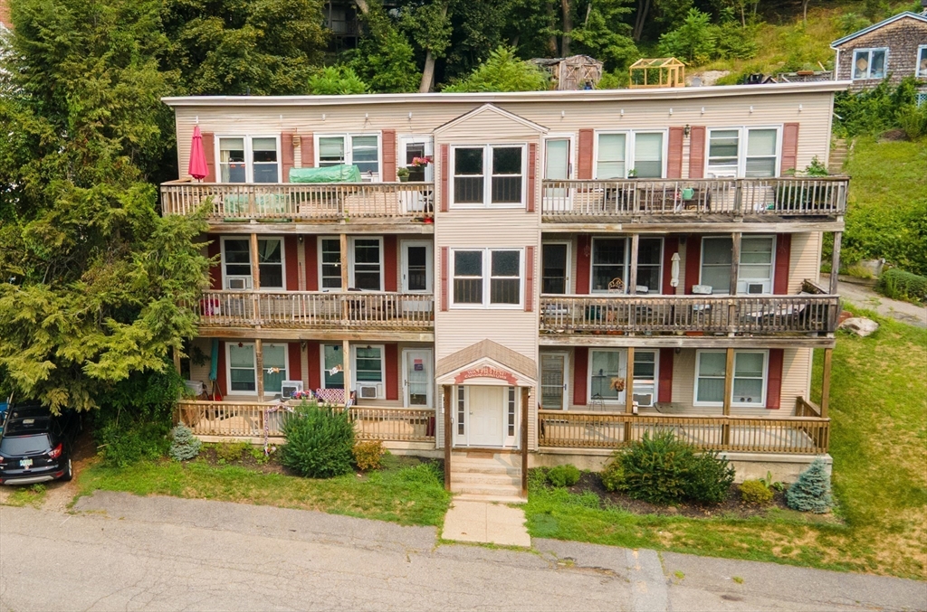 40 Nashua Street, Unit 5 Clinton, MA 01510 - Photo 33 of 33 a front view of a residential apartment building with a yard and potted plants