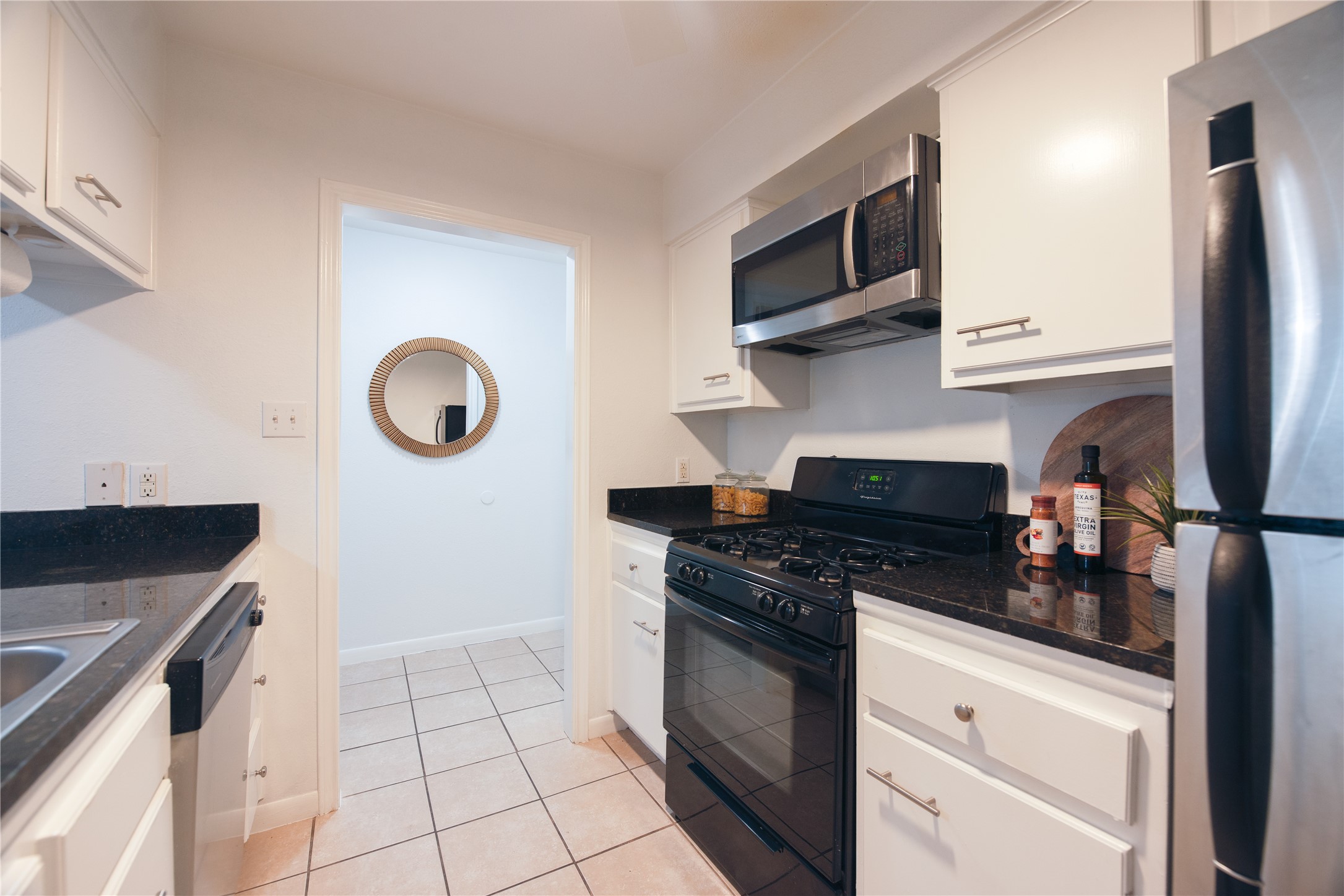 4209 Burnet Road, Unit 106 Austin, TX 78756 - Photo 11 of 17 a kitchen with stainless steel appliances granite countertop a stove and a microwave