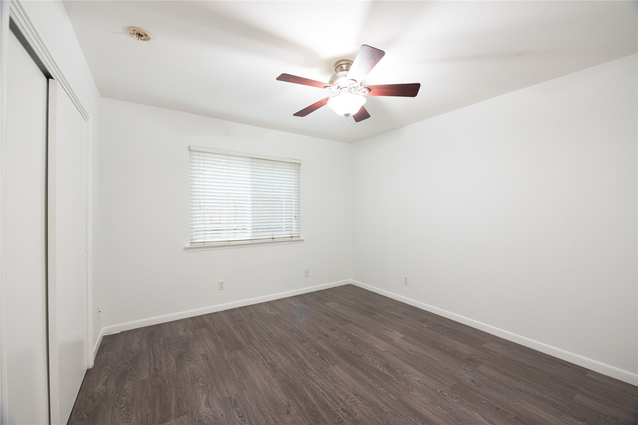 4209 Burnet Road, Unit 106 Austin, TX 78756 - Photo 13 of 17 an empty room with wooden floor fan and windows