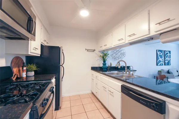 a kitchen with stainless steel appliances granite countertop a sink stove and cabinets