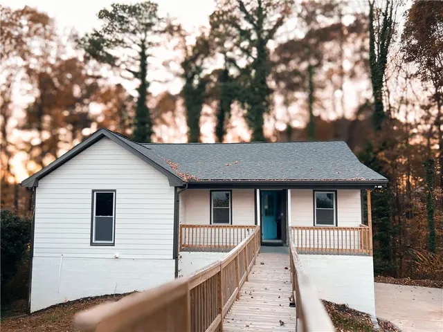 a front view of a house with a tree
