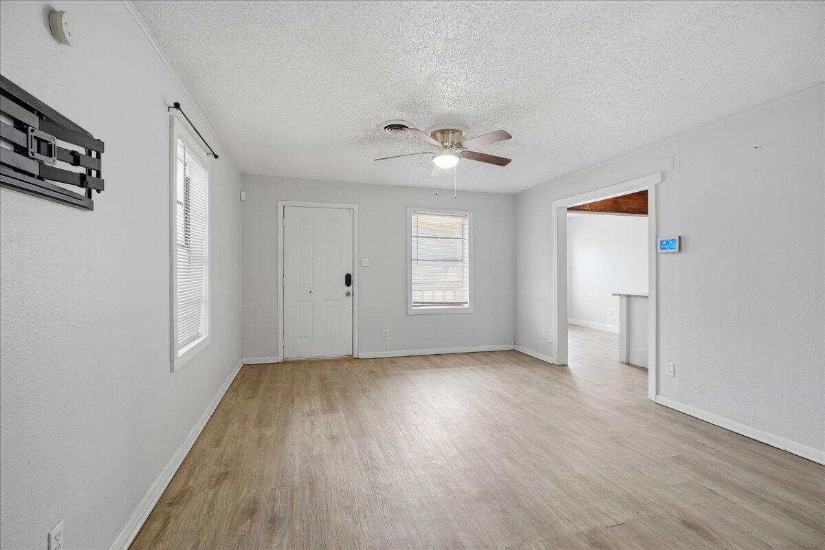 2503 30th Street Lubbock, TX 79410 - Photo 5 of 26 an empty room with wooden floor chandelier fan and windows
