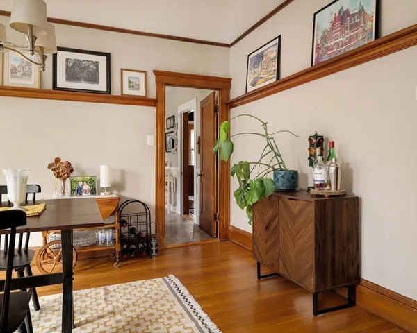 a dining room with furniture a floor to ceiling window and wooden floor