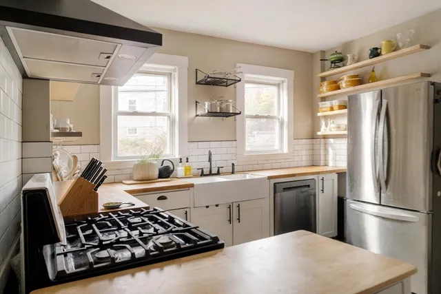 a kitchen with stainless steel appliances a stove a sink and a refrigerator