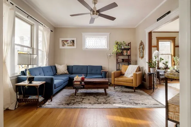 a living room with furniture wooden floor and a large window