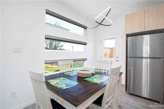 a view of a dining room with furniture a potted plant and wooden floor
