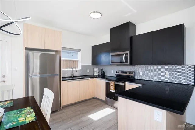 a kitchen with granite countertop a refrigerator a stove a sink a washer and dryer