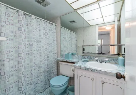a bathroom with a granite countertop sink a toilet and a mirror