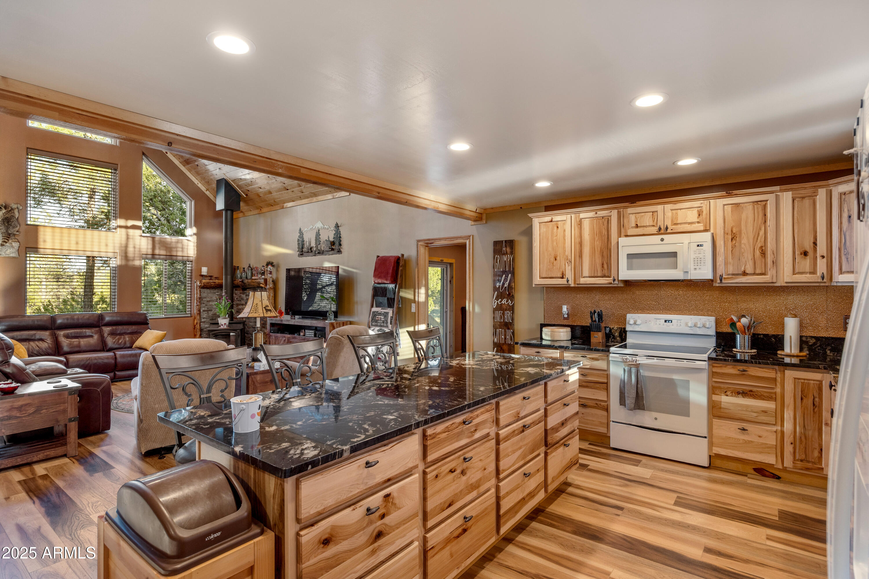 3334 Sawmill Ridge Loop Heber, AZ 85928 - Photo 14 of 58 a kitchen with stainless steel appliances granite countertop a stove top oven a sink dishwasher a dining table and chairs with wooden floor