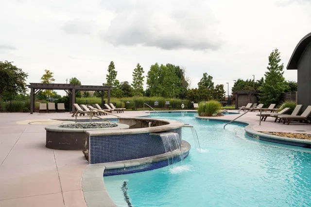 a view of a tennis ground with large trees