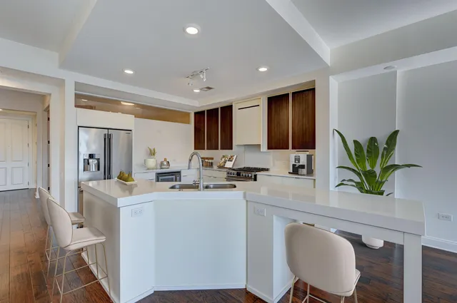 a kitchen with sink a microwave and dining table with wooden floor