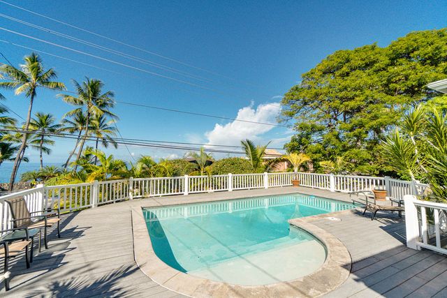 a view of a swimming pool with a patio and a bench