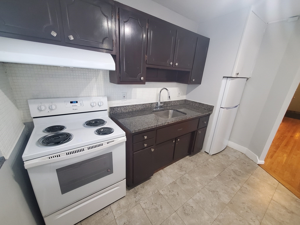 24 Colgate Road, Unit 5 Boston, MA 02131 - Photo 2 of 13 a kitchen with a stove sink and cabinets