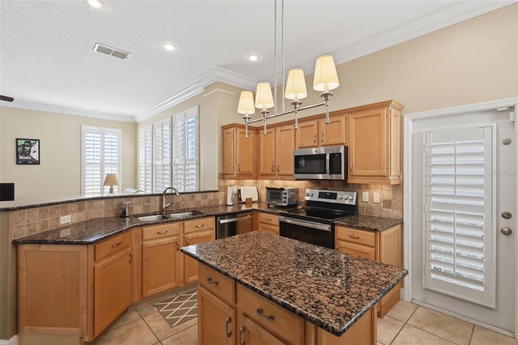 907 Pawstand Road Celebration, FL 34747 - Photo 19 of 49 a kitchen with stainless steel appliances granite countertop a sink stove and refrigerator