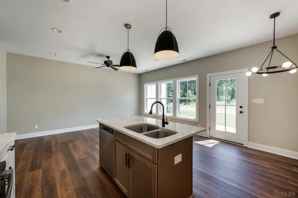 a kitchen with kitchen island stainless steel appliances a sink stove and wooden floor