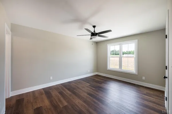 a view of a big room with wooden floor and windows