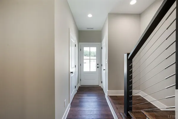 a view of a hallway with wooden floor and staircase