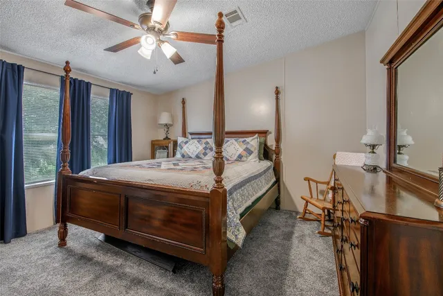 a spacious bedroom with a bed and a flat screen tv