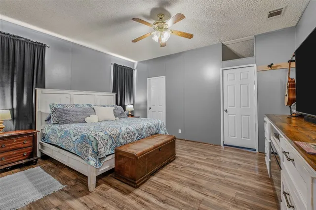 a backyard of a house with table and chairs under an umbrella