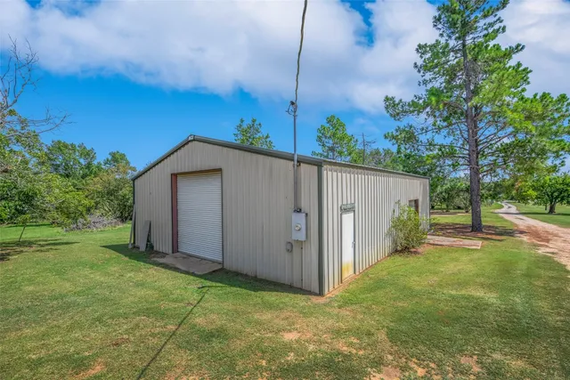 a backyard of a house with a tree and wooden fence