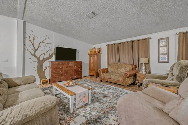 a view of a livingroom with furniture wooden floor and windows
