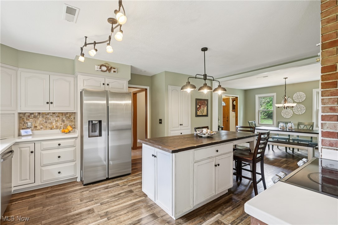 4101 Huffman Road Medina, OH 44256 - Photo 6 of 48 Kitchen with appliances with stainless steel finishes, white cabinetry, decorative backsplash, and wood finished floors