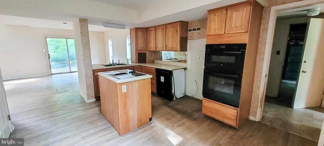 533 Pugh Road Wayne, PA 19087 - Photo 9 of 27 a kitchen with granite countertop a refrigerator a stove a sink and dishwasher with wooden floor