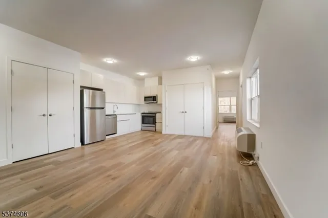 a view of a kitchen with a sink and wooden floor