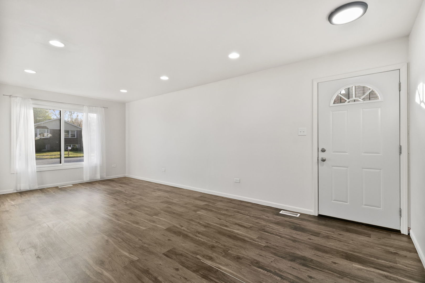 2236 West 157th Place Markham, IL 60426 - Photo 2 of 14 a view of an empty room with wooden floor and a window