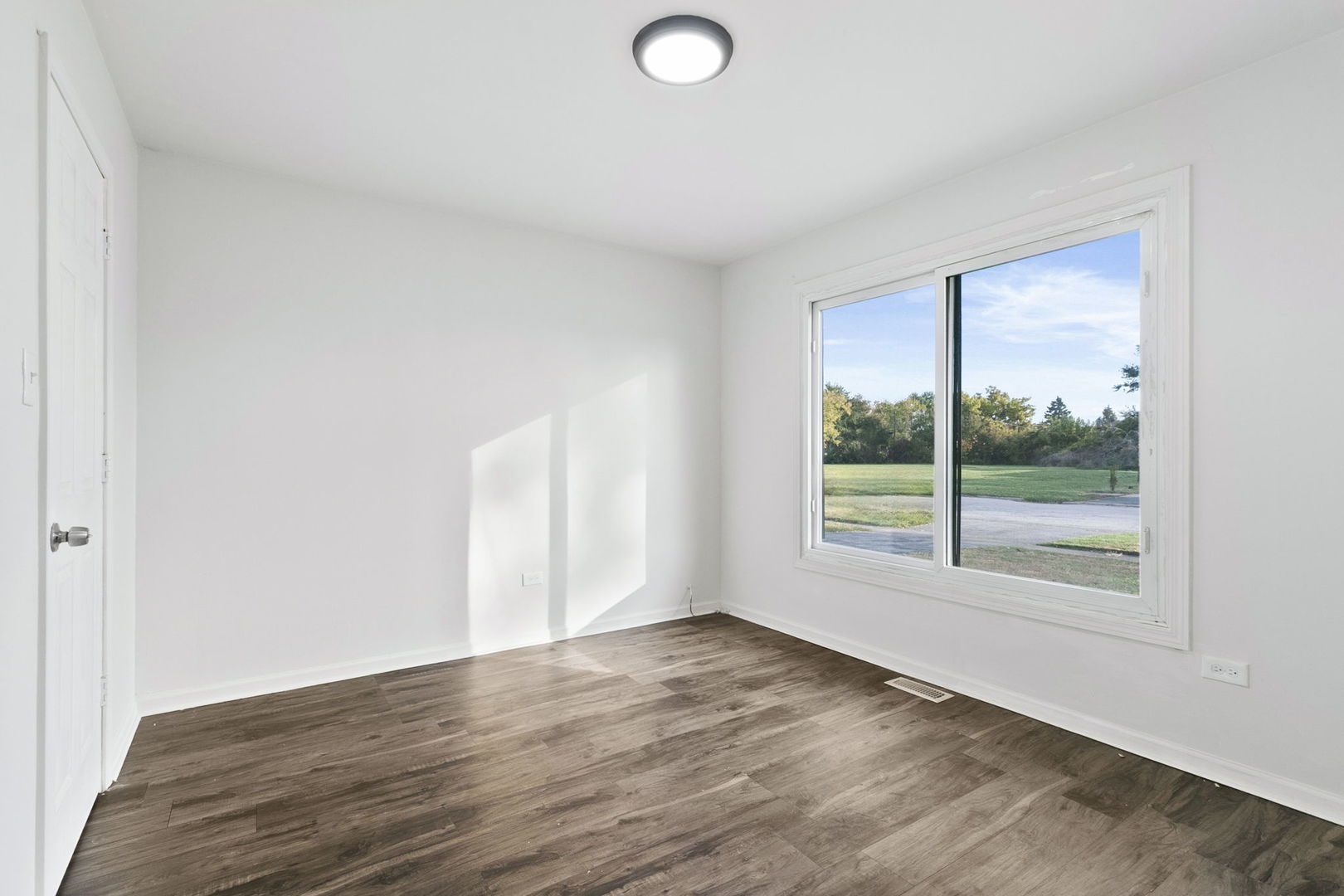 2236 West 157th Place Markham, IL 60426 - Photo 4 of 14 an empty room with wooden floor and windows