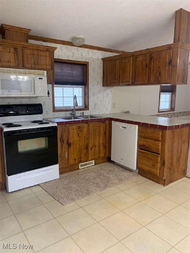 27216 Cook Road, Unit 24 Olmsted Falls, OH 44138 - Photo 6 of 23 Kitchen with white appliances, ornamental molding, sink, tile countertops, and light tile patterned floors