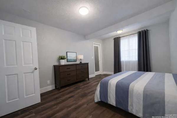 a bedroom with a bed and wooden floor