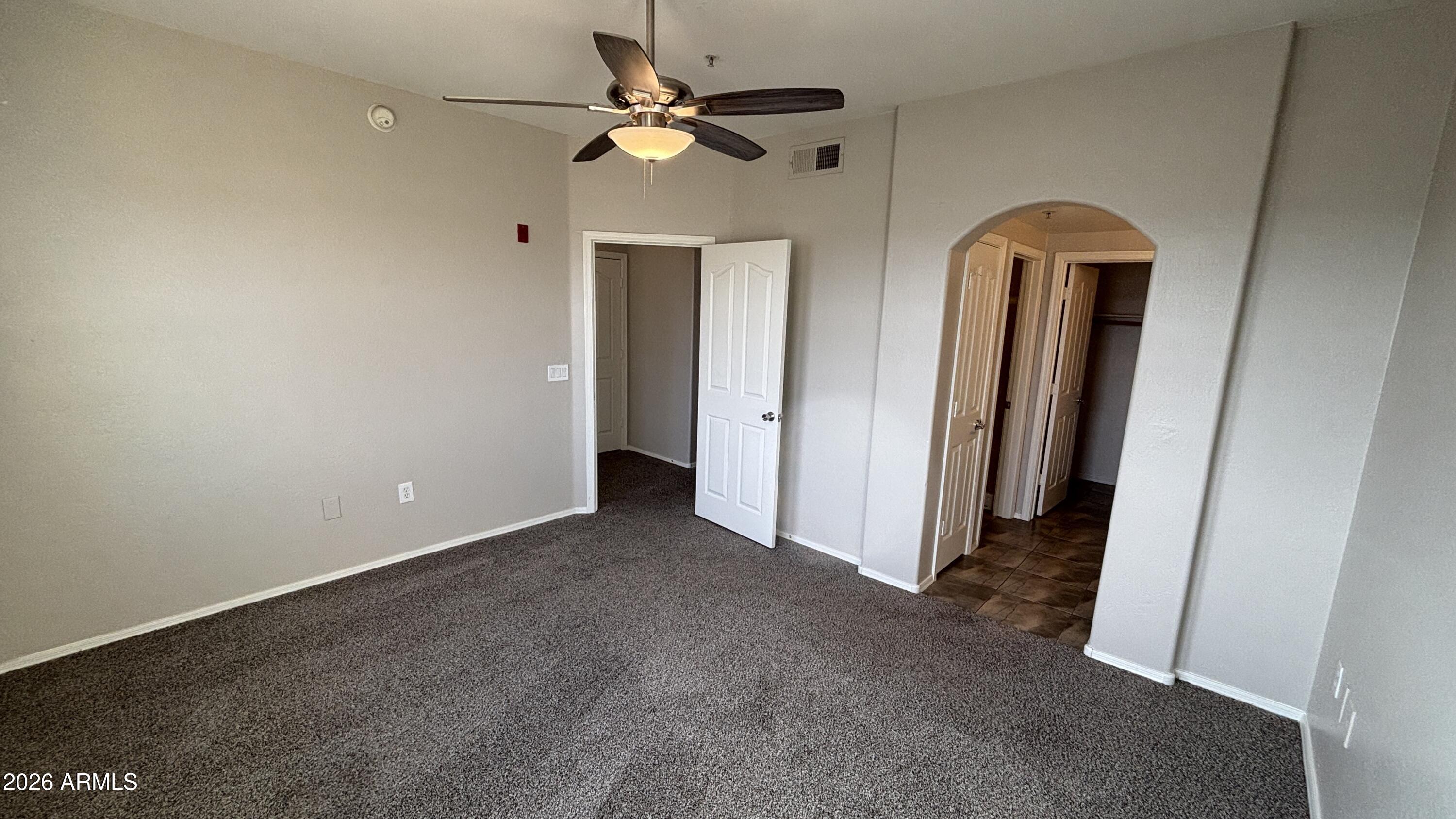 3250 West Greenway Road, Unit 104 Phoenix, AZ 85053 - Photo 13 of 26 an empty room with windows and fan